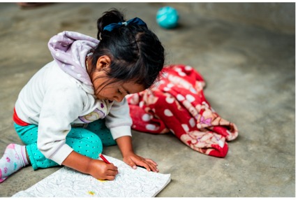 Niña dibujando sobre su nuevo piso de concreto